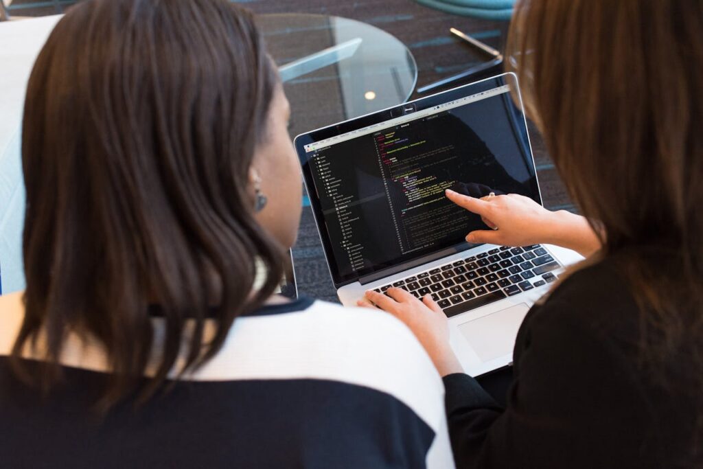 pexels photo 1181263 Two women working together on software programming indoors, focusing on code.