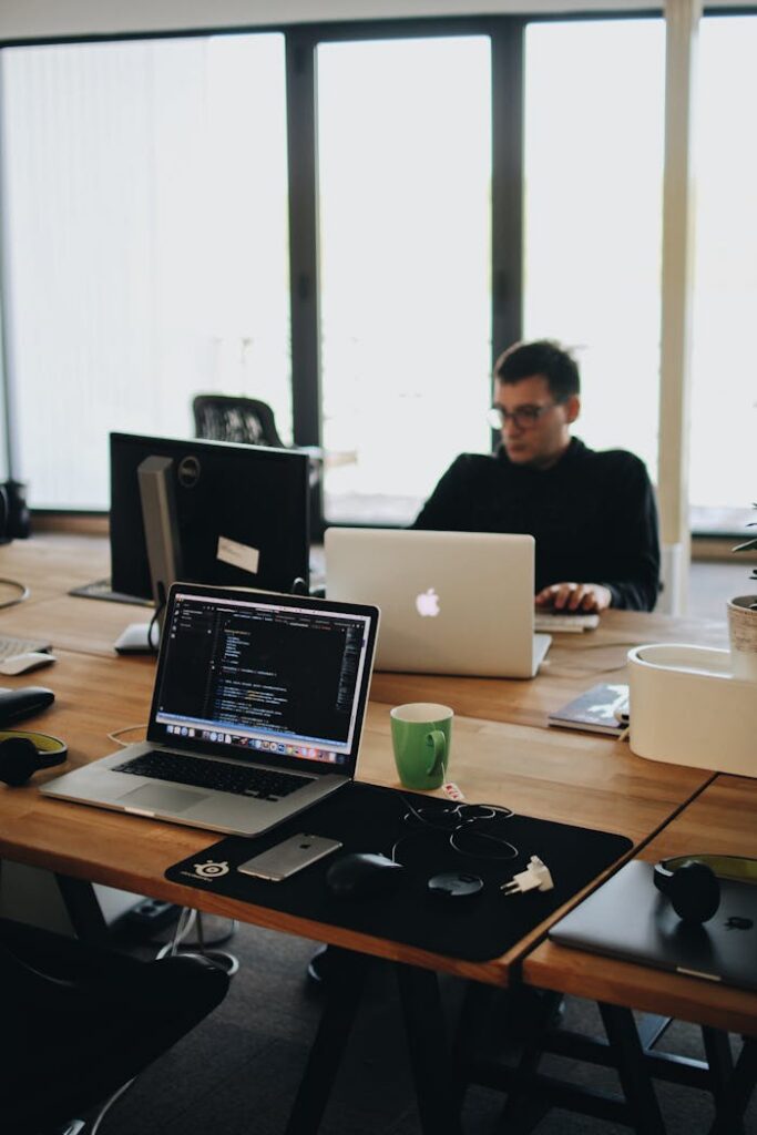 pexels photo 2102416 A web developer working on code in a modern office setting with multiple devices.